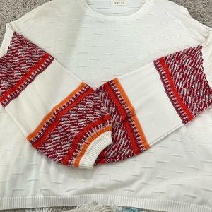 White, red, and orange sweaters from Roolee.